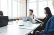 © xartproduction - Group of young business people working and communicating while sitting at the office desk together with colleagues sitting. business meeting