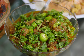 Canvas Print - A closeup of a bowl of delicious chicken with sauce, fresh pepper, and coriander on the table