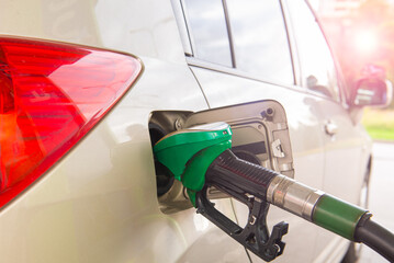 Refueling Car fill with petrol gasoline at gas station and Petrol pump filling fuel nozzle in fuel tank of a car. Travel and transportation. Car trip.