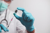 Fototapeta Dmuchawce - doctor or scientist in the COVID-19 medical vaccine research and development laboratory holds a syringe with a liquid vaccine to study and analyze antibody samples for the patient.
