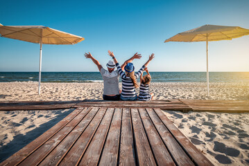 Wall Mural - funny family in striped clothes at the beach