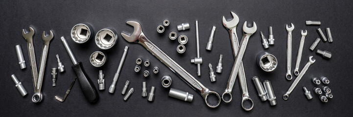 Tool set on black background. Mechanic tools, wrenches or spanners. Technique repair, equipment for mechanical service, labor or father's day concept. Flat lay, top view, banner