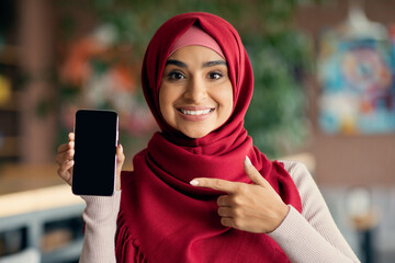 Wall Mural - Pretty religious woman showing cellphone with empty screen