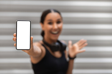 Sports App. Excited Woman In Sportswear Demonstrating Smartphone With Blank White Screen