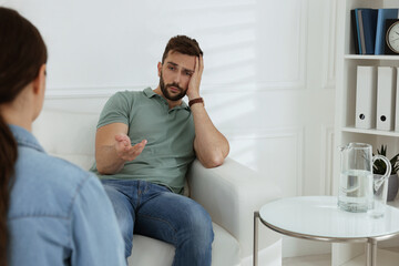 Wall Mural - Unhappy man having session with his therapist indoors