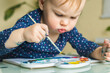 © Fraupoc - Cute little girl painting picture on home interior background. Cute little toddler girl drawing.