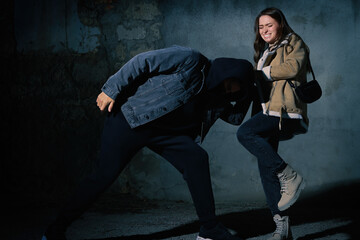 Canvas Print - Woman defending herself from attacker outdoors at night