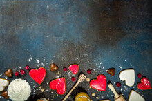 Valentine Day Sweet Cooking Background. Baking Ingredients And Utensils - Flour, Rolling Pin, Heart Shaped Biscuits, Eggs. Making Cute Valentine`s Sweet Gift. Top View Copy Space On Dark Background