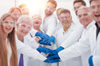 © ASDF - group of medical lab employees joining their palms together.