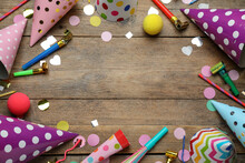 Frame Made Of Colorful Party Hats And Other Festive Items On Wooden Table, Flat Lay. Space For Text
