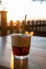 Wall Mural - Cup of Latte coffee on wooden coffee table.  Coffee break in the morning, relaxing and refreshing concepts. A white coffee cup on wooden table in the garden.