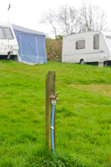 Clean water tap on caravan site in rural Wales UK set up to provide drinking water for the holiday makers .