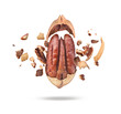 Chopped pecan nuts with shells on white plate in the air