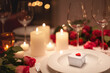 Valentinstag zu Hause - romantisch gedeckter Tisch mit roten Rosen und einem kleinen Geschenk