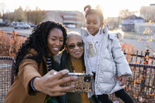 Happy Female Multigenerational Family Taking Selfie In Winter Park