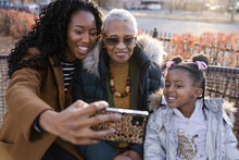 Happy Female Multigenerational Family Taking Selfie In Park