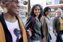 Happy Mature Women Friends Walking On Urban Sidewalk