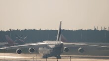  Huge cargo transport four-engine aircraft speed up before takeoff, rear view
