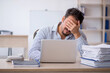 © Elnur - Young male employee and too much work in the office