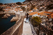Laughing young woman tourist walking on the city walls of dubrovnik in croatia. Travel photography