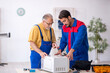 © Elnur - Two male repairmen working at workshop