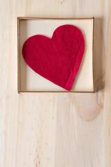 Wall Mural - red felt heart in a shallow box on a wooden surface