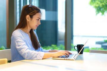 Wall Mural - Portrait of a smart Asian girl freelance working online from home. with laptop at home Living room in Coronavirus or Covid-19 outbreak situation