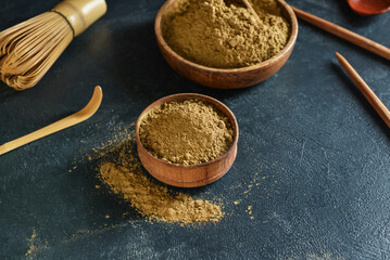 Wall Mural - Bowls with hojicha powder on black background