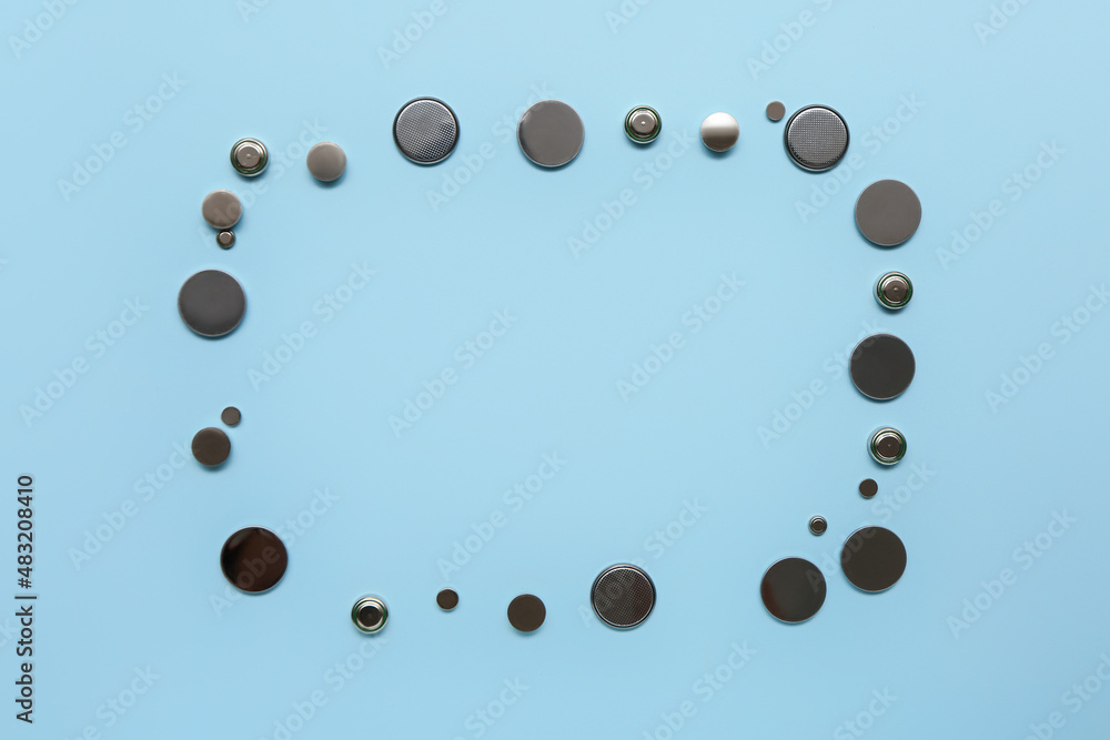 Frame made of lithium button cell batteries on blue background