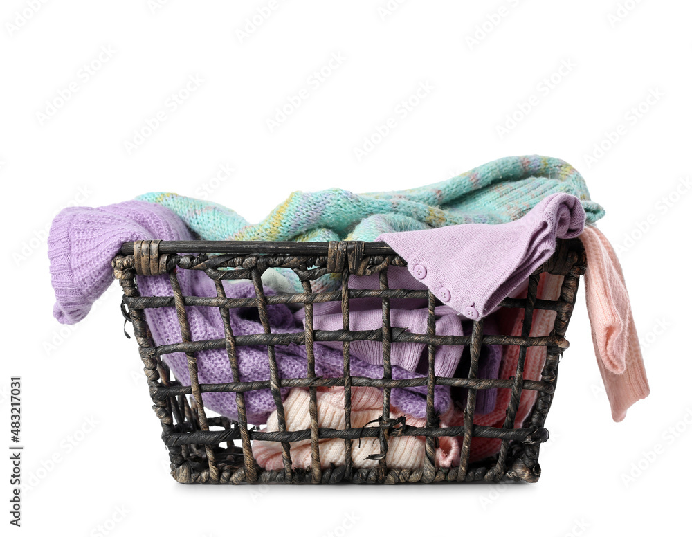 Basket with different sweaters on white background