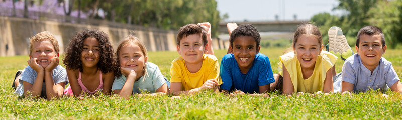 Portrait of smiling children who are posing lying in the park