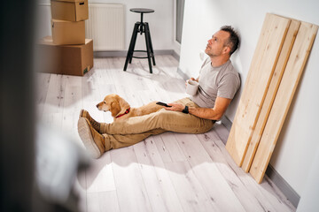 Wall Mural - a man with his dog moves into a new empty apartment