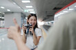 © tigercat_lpg - Young beautiful Asian female tourist taking portrait photo with film camera with friend, smile and enjoyment at train station platform, happy travel lifestyle by subway transport vacation trip.