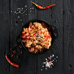 Canvas Print - Chicken fried rice on wok. Asian food - fried rice with vegetables, egg and chicken on dark table. Wok menu on black wood background. Traditional chinese food.