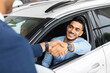© Prostock-studio - Cheerful arabic man sitting in new white car, shaking hand