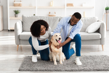 Poster - Happy black couple spending time at home with their pet