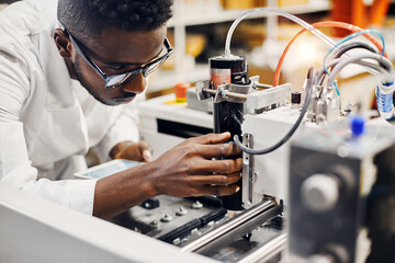 african engineer programming equipment with tablet at factory