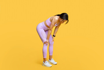 Wall Mural - Sport, catch breath and rest. Tired black woman taking break in workout, leaning on knees, yellow background