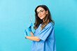 © luismolinero - Woman dentist holding tools over isolated on blue background pointing back