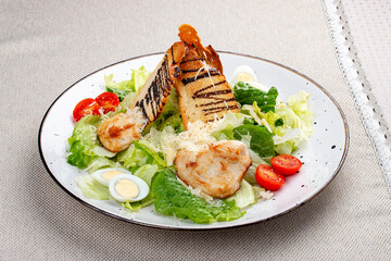 Wall Mural - Caesar salad with chicken on a white decorative plate. A classic salad.