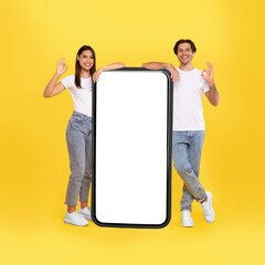 Wall Mural - couple showing white empty smartphone screen and gesturing ok