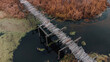 Old, wooden, small bridge on river, chilly day. aerial view