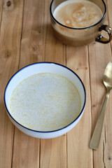 Sticker - Rice milk porridge. Side view, wooden background.