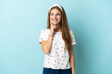 Young caucasian woman over isolated background thinking an idea while looking up