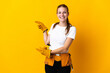 © luismolinero - Young electrician woman isolated on yellow background surprised and pointing side