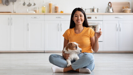 Wall Mural - Smiling chinese lady with cute doggy showing pets supplement jar