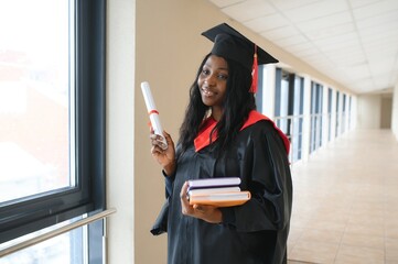 Wall Mural - beautiful young afro american graduate holding diploma