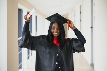 Wall Mural - beautiful young afro american graduate holding diploma