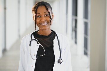 Wall Mural - Closeup portrait of friendly, smiling confident female healthcare professional with lab coat, stethoscope. Isolated hospital clinic background. Time for an office visit