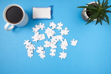 Jigsaw Puzzle Pieces Scattered Around The Table With Coffee Access Card And